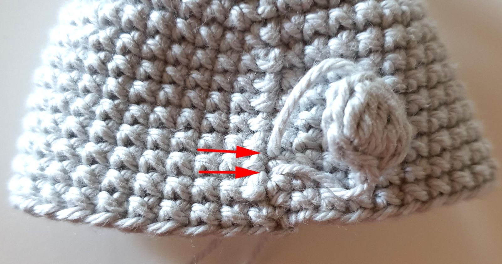 Die Fäden des Schwänzchen sind im Häkelstück nach innen durchgefädelt.