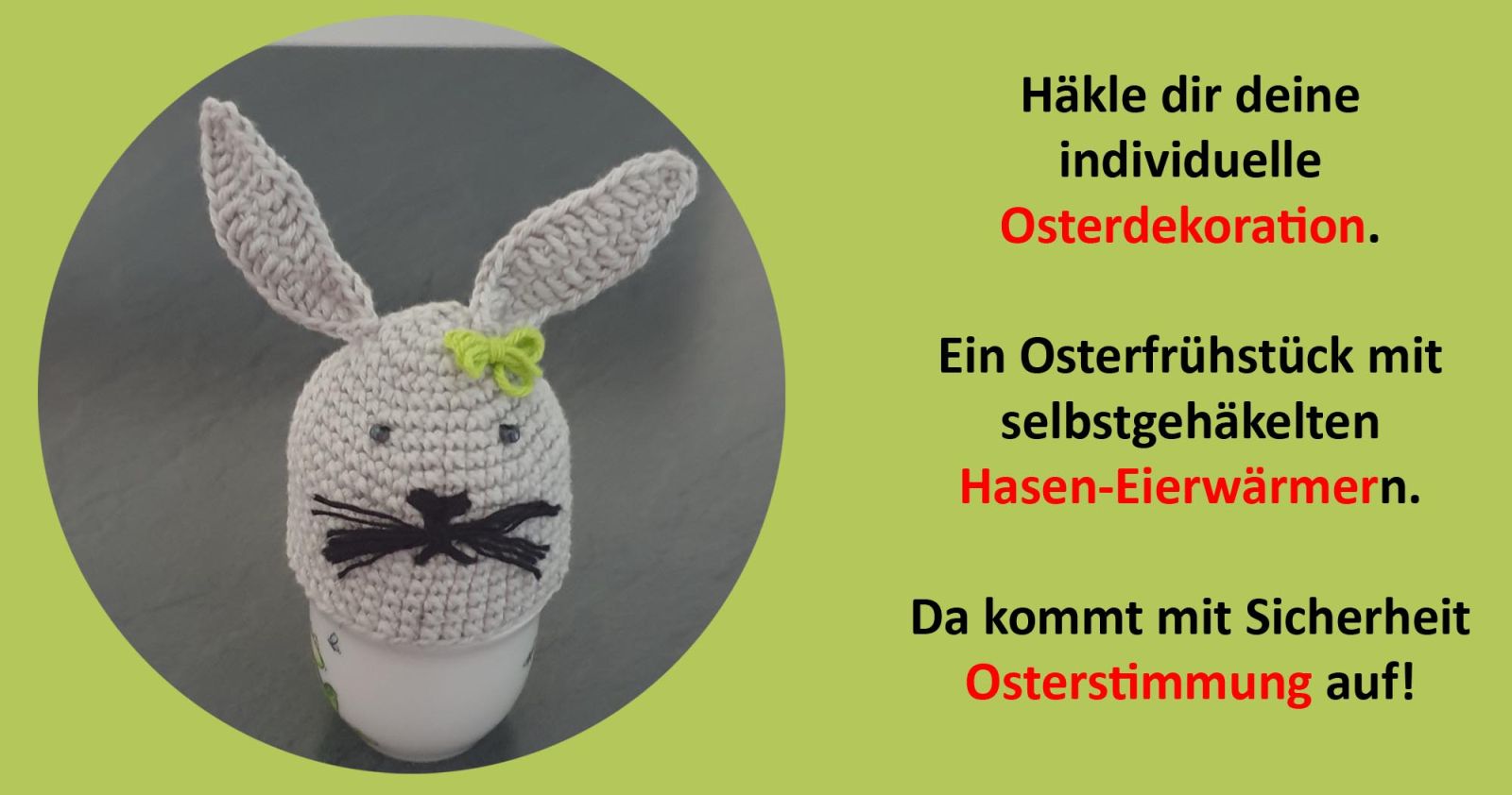 Ein gehäkelter Hase als Eierwärmer mit einer grünen Schleife am Ohr und einen süßen Gesicht mit Schnurrbarthaaren.