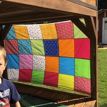 Ein Wind- und Sonnenschutz fürs Spielhaus. Dafür habe ich viele bunte gleichgroße Baumwollstoffteile (Reste, Tücher etc.) aneinandergenäht. Oben und unten habe ich noch ein stabiles Gummiband mit seitlichen Schlaufen angenäht.