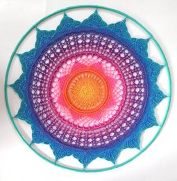 Tolle Anleitung! Gut zum nachhäkeln!
Ich habe das Mandala in einen Metrallring mit 75cm Durchmesser eingehäkelt.